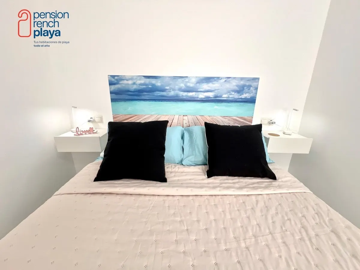 Cama doble y cabecero con fotografía del mar en la habitación premium